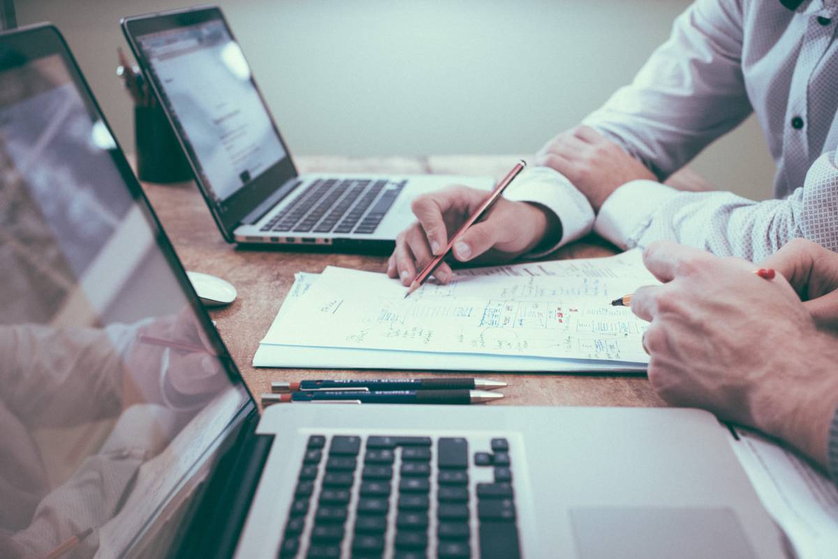 People working with computers and paper to process survey results